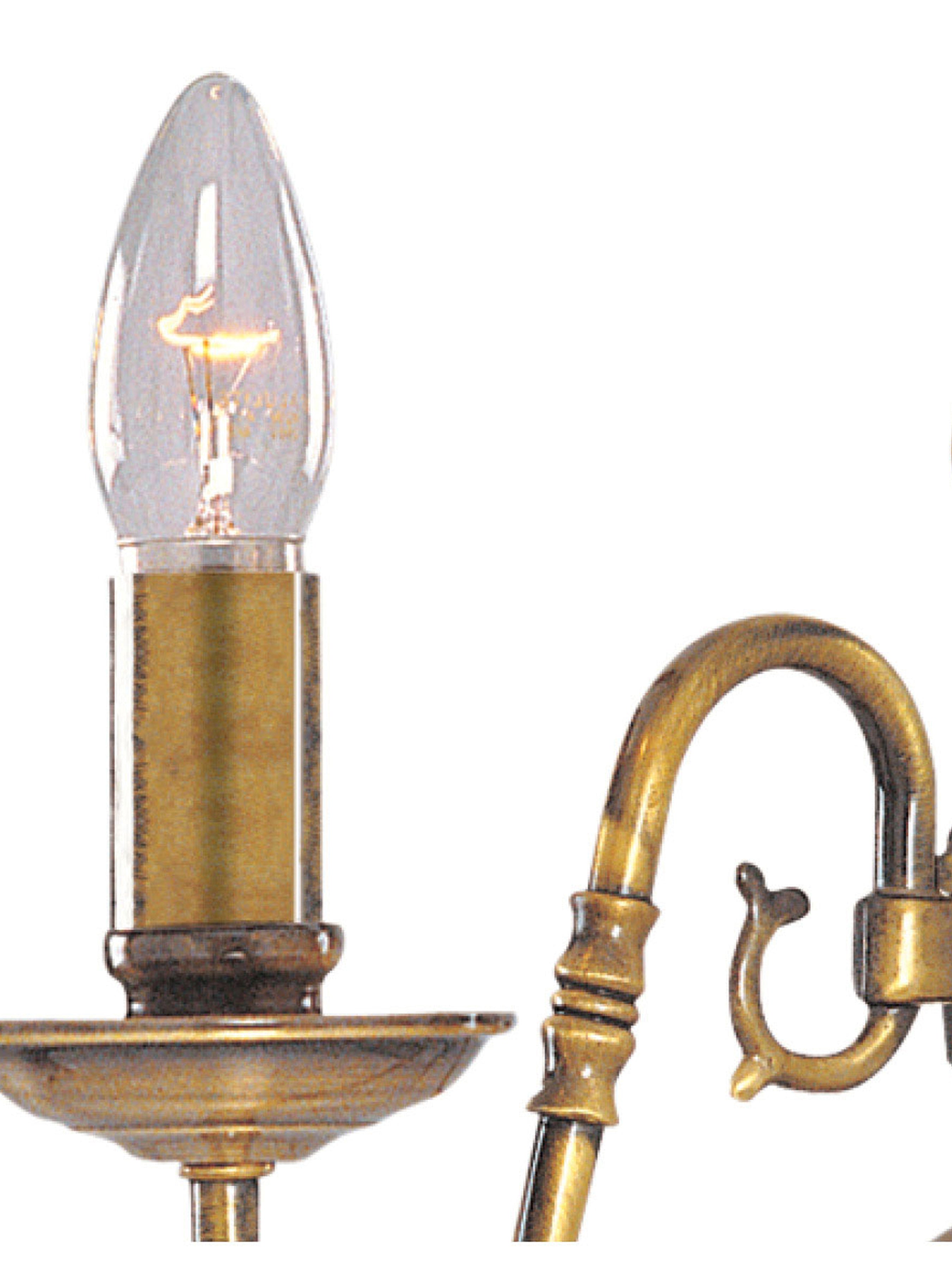 Close-up of a brass candle-style light fixture, highlighting the bulb and intricate details.