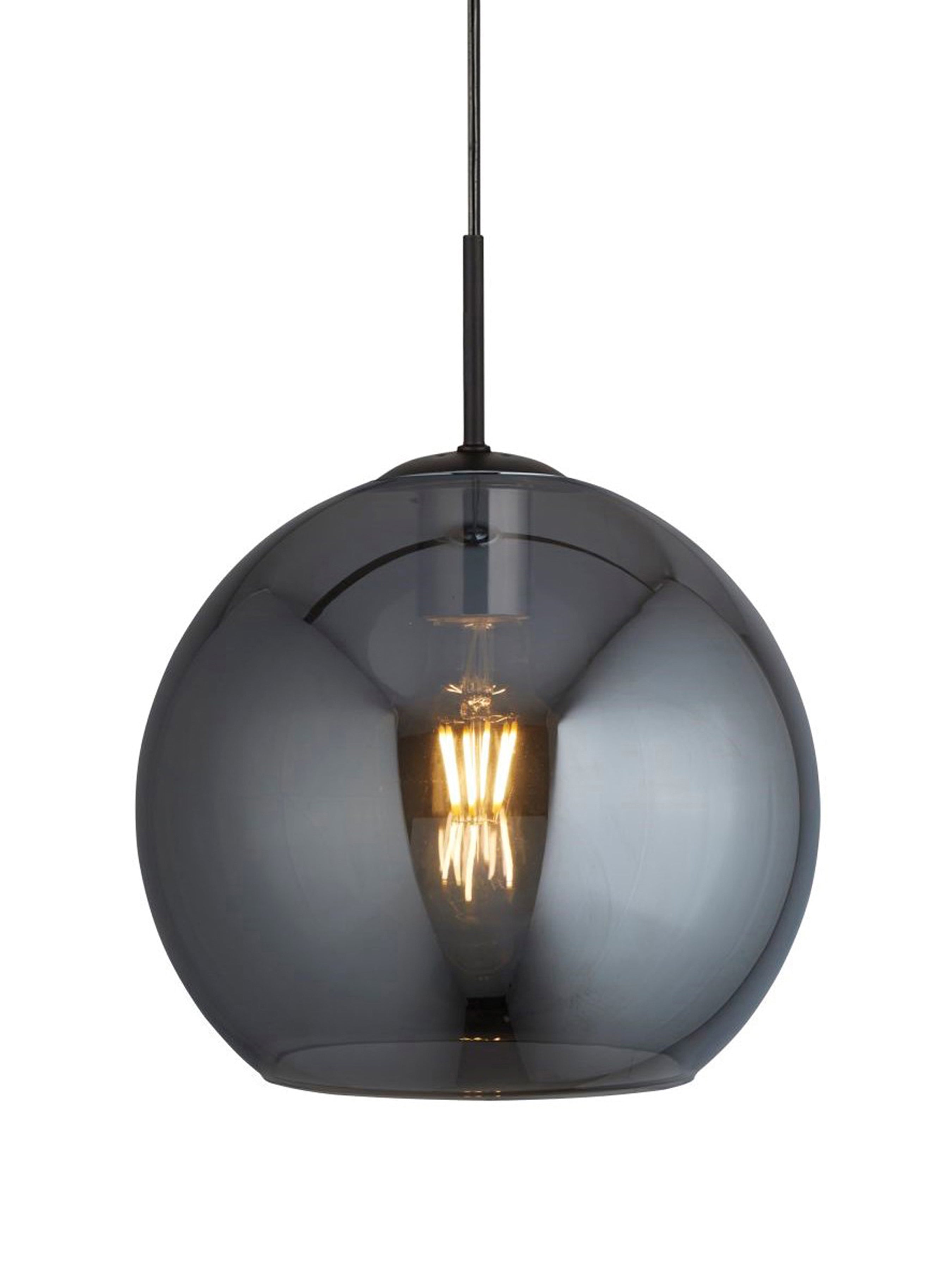 A dark glass pendant light with an Edison bulb, casting a warm glow.