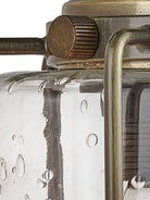 A close-up of the seeded glass and brass details on a wall light.