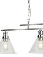 Close-up of a brushed nickel linear light fixture with two clear glass cone shades and bulbs.