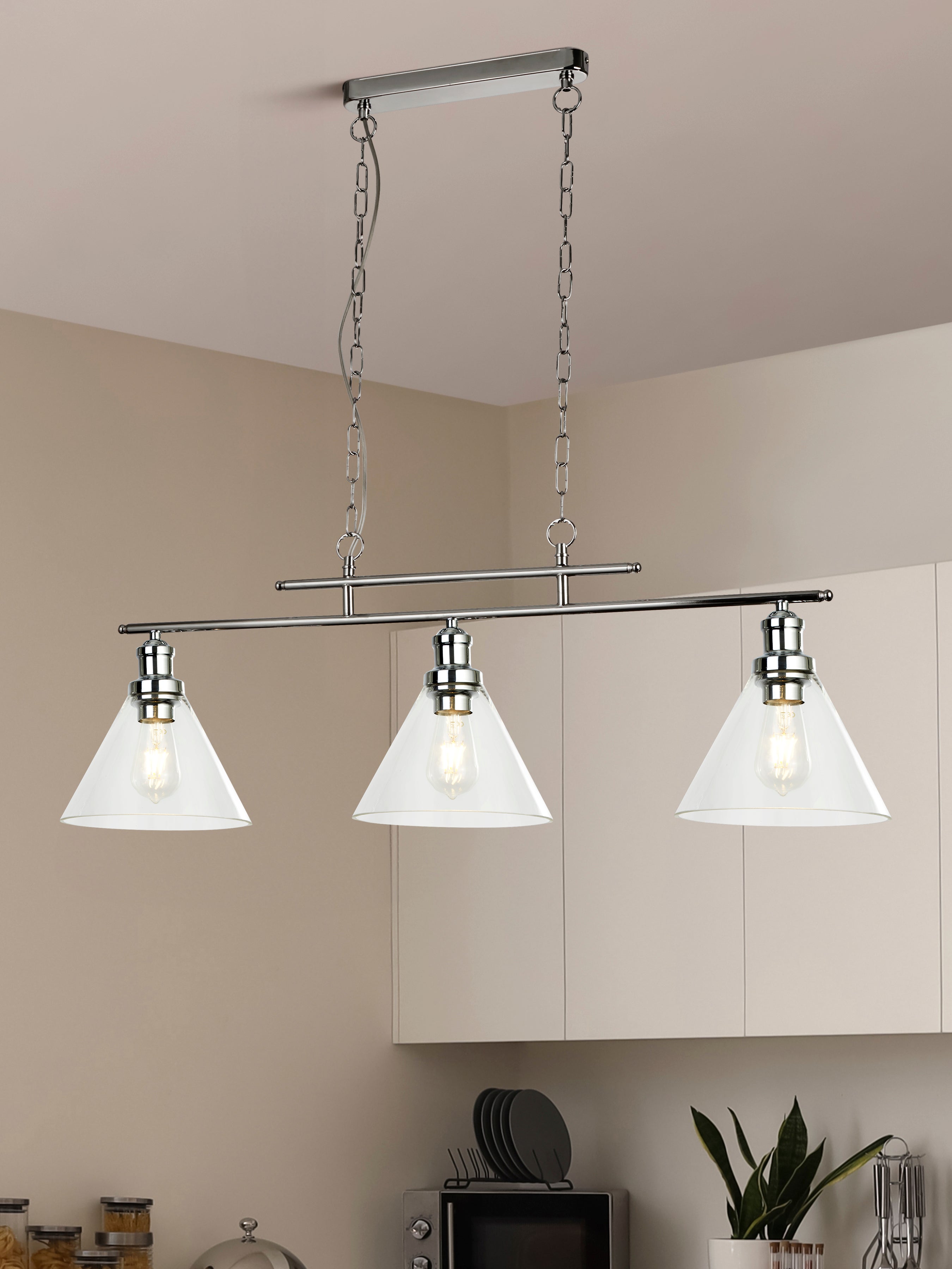 Linear light fixture with three clear glass cone shades in a modern kitchen setting.
