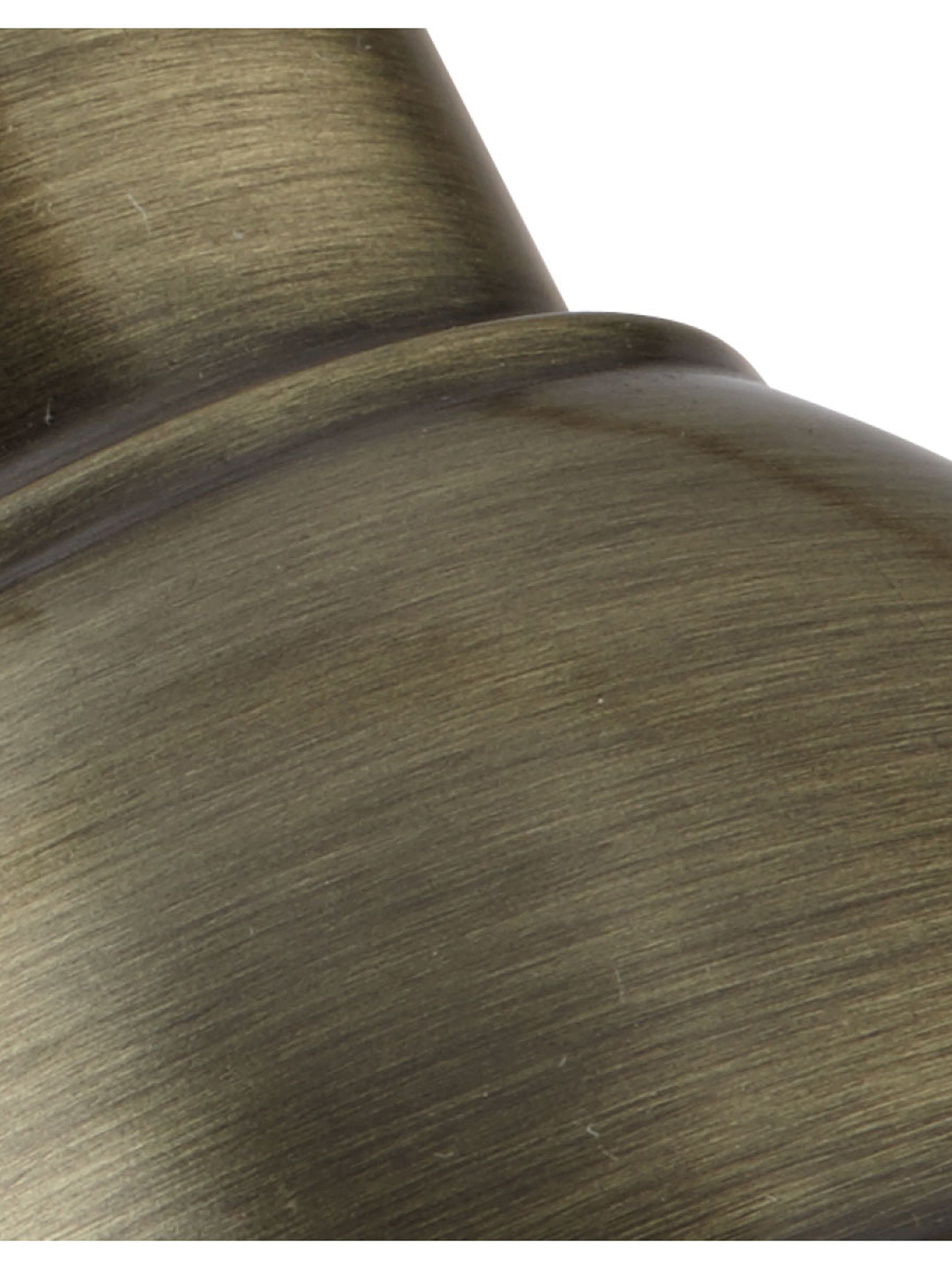 A detailed close-up of the aged brass finish on a wall light fixture.