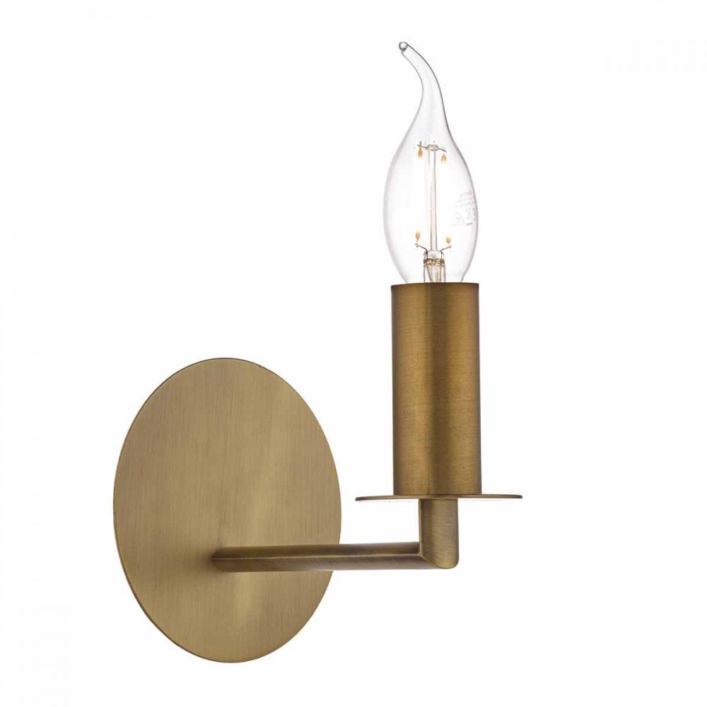 A brass wall light with a clear, flame-shaped bulb exposed.