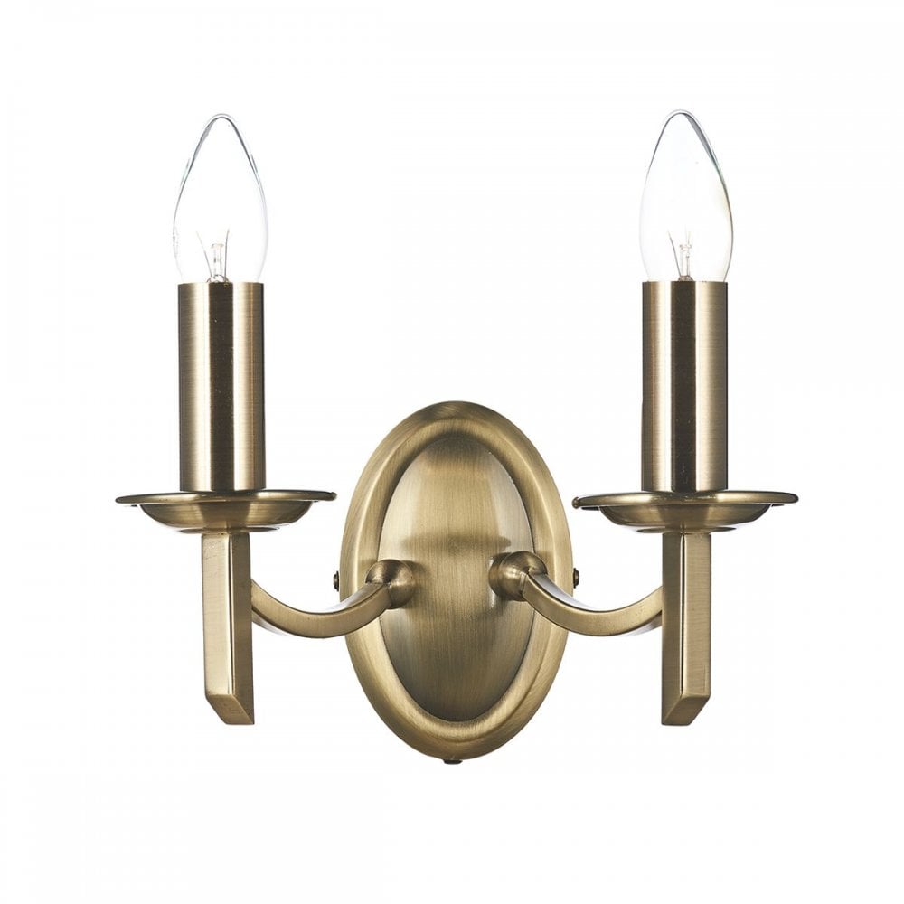 Classic brass twin wall light with exposed candle-style bulbs.
