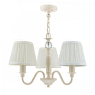 A cream-colored three-arm chandelier with pleated fabric shades and a glass accent.
