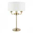 Classic brass table lamp with a white drum shade, perfect for traditional decor.