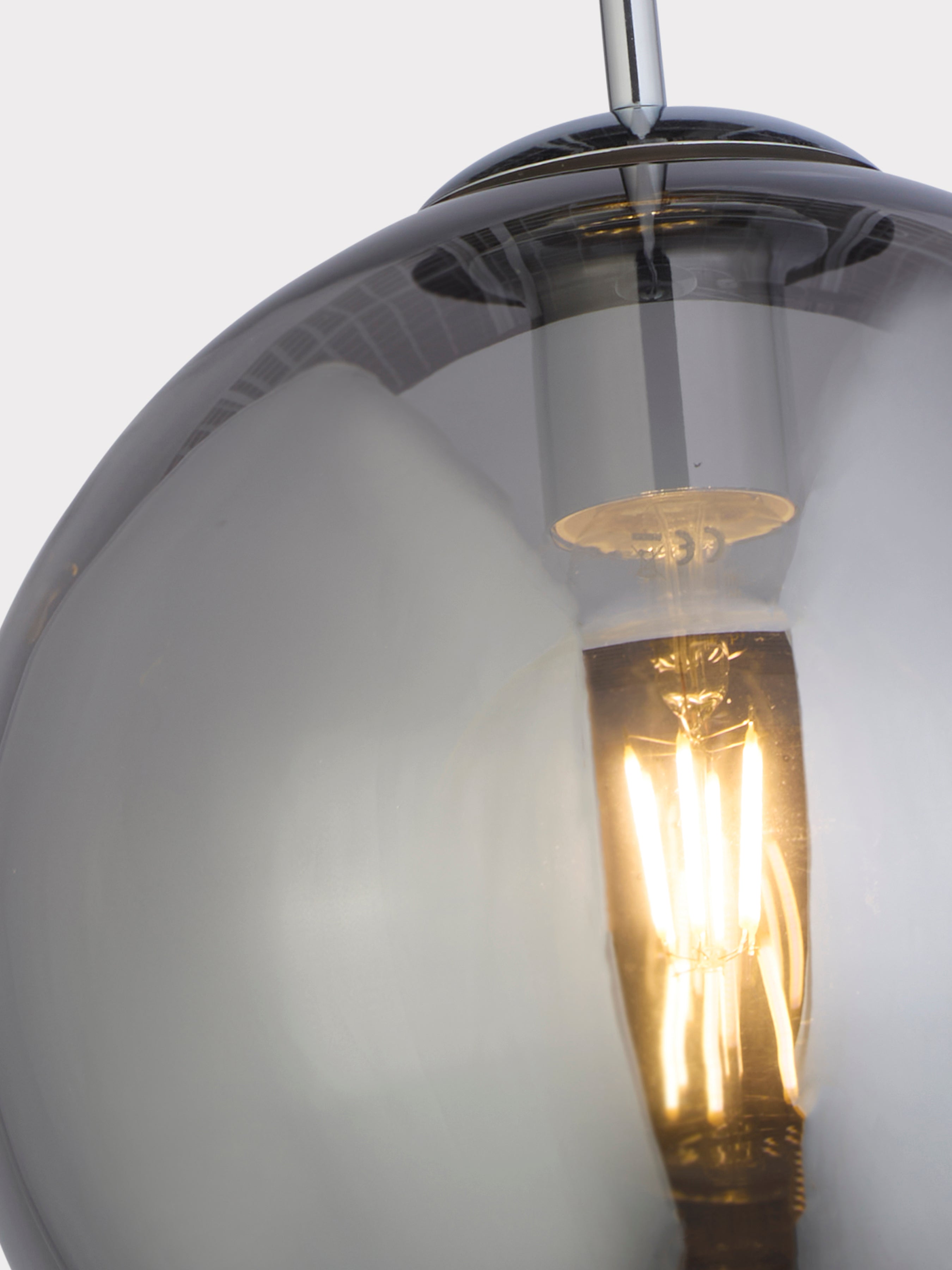 A detailed view of the smoked glass shade and exposed filament bulb.