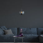 Pendant light hanging above a coffee table in a modern living room setting.