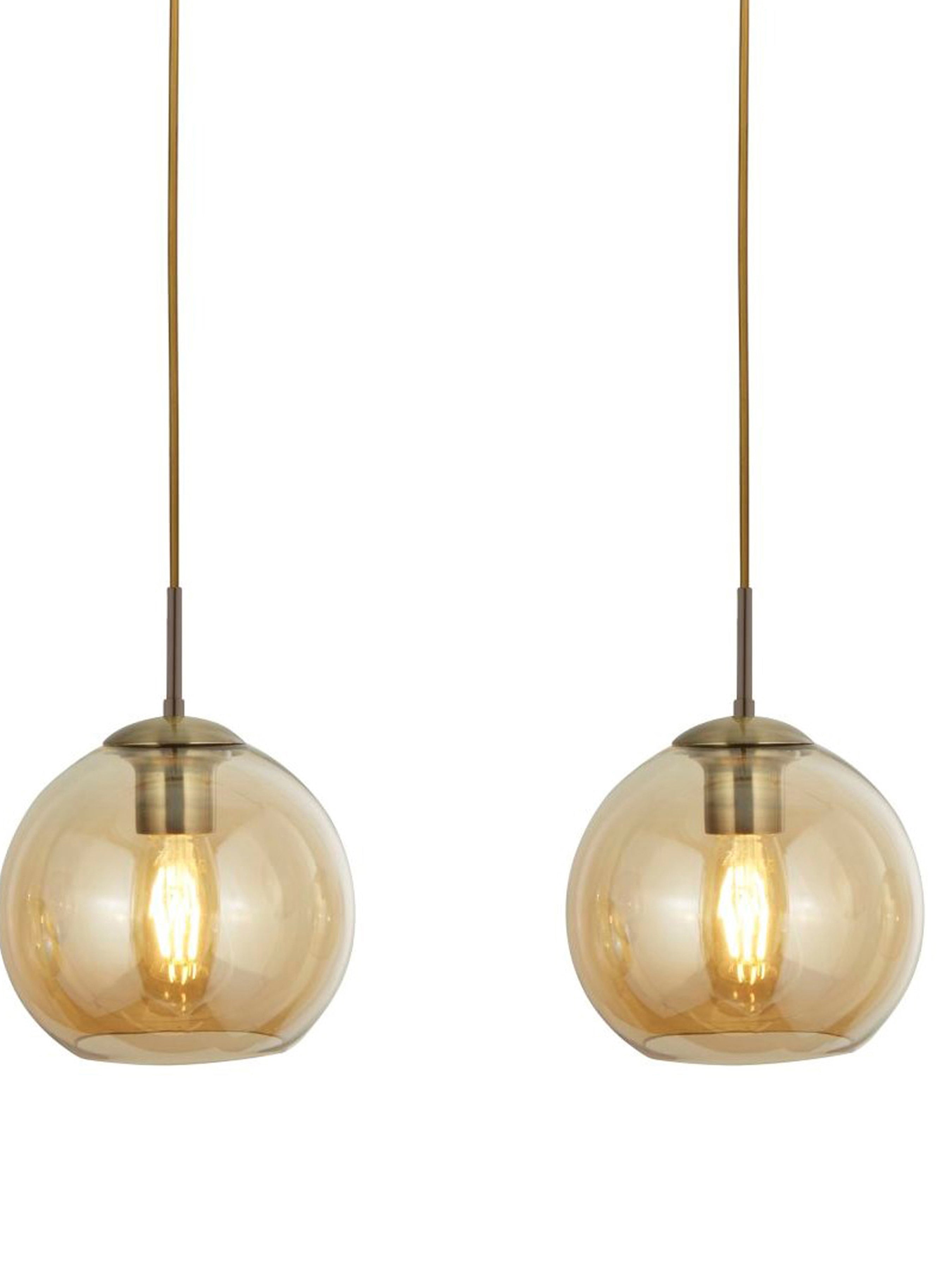 Two illuminated amber glass globe pendant lights with brass fittings on a white background.