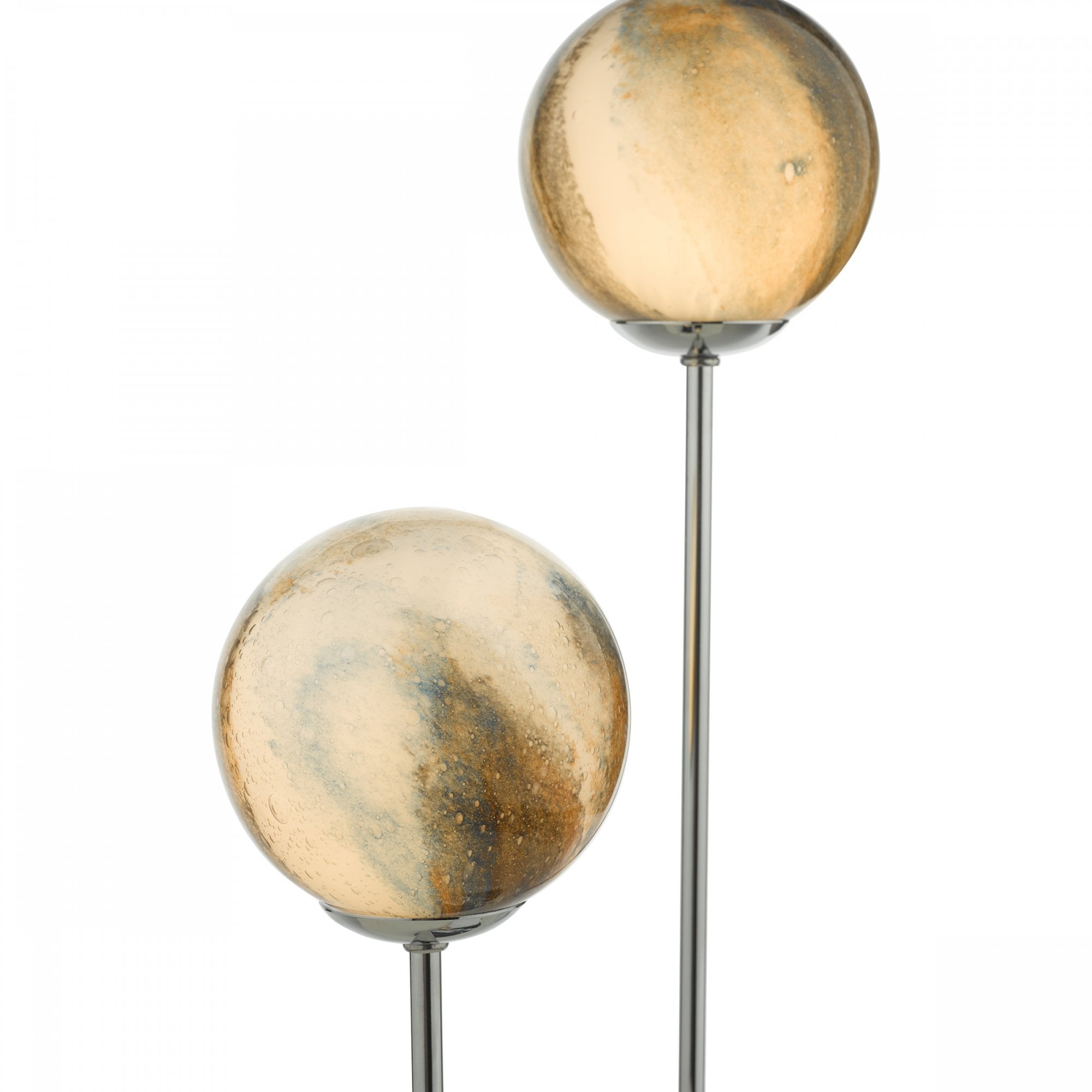 Close-up of the two spherical, warm-toned, patterned glass shades of the table lamp.