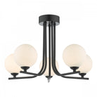 A black ceiling light with five spherical white glass shades on a white background.