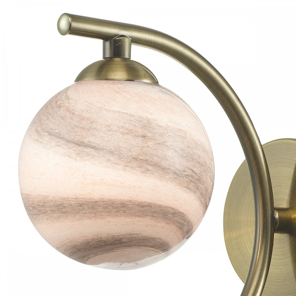 A close-up of the marbled globe shade and brass fixture of a wall light.