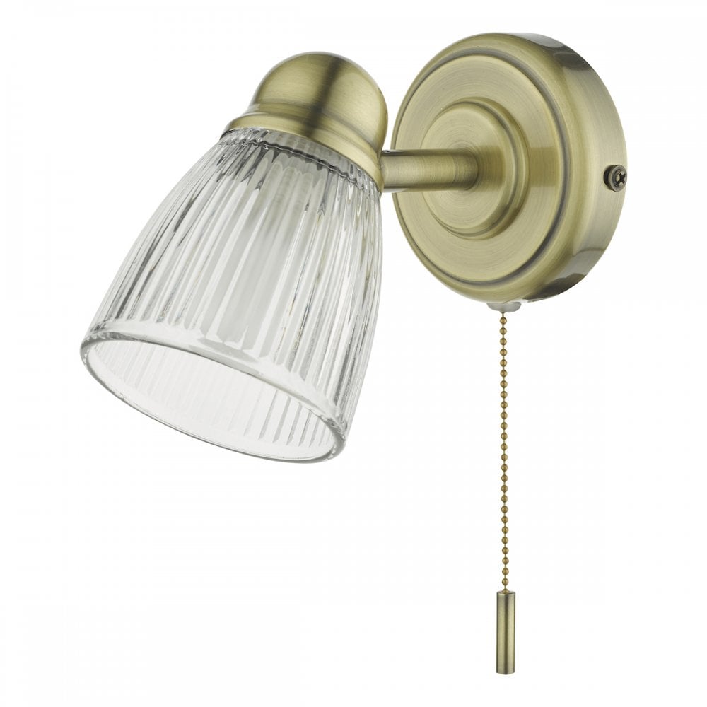 A brass wall light featuring a fluted glass shade and a chain pull switch.