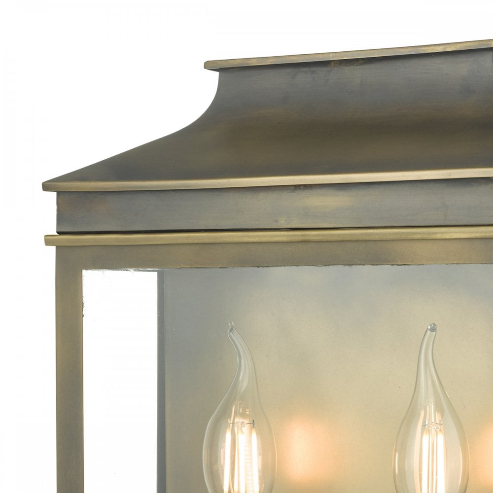 A close-up of the top and bulbs of a brass outdoor wall lantern.