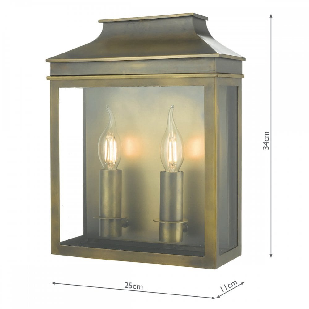A brass outdoor wall lantern with two lit, candle-style bulbs, with its dimensions noted.