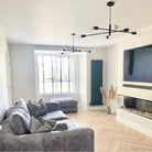 A stylish living room featuring two black sputnik chandeliers and a grey sofa.