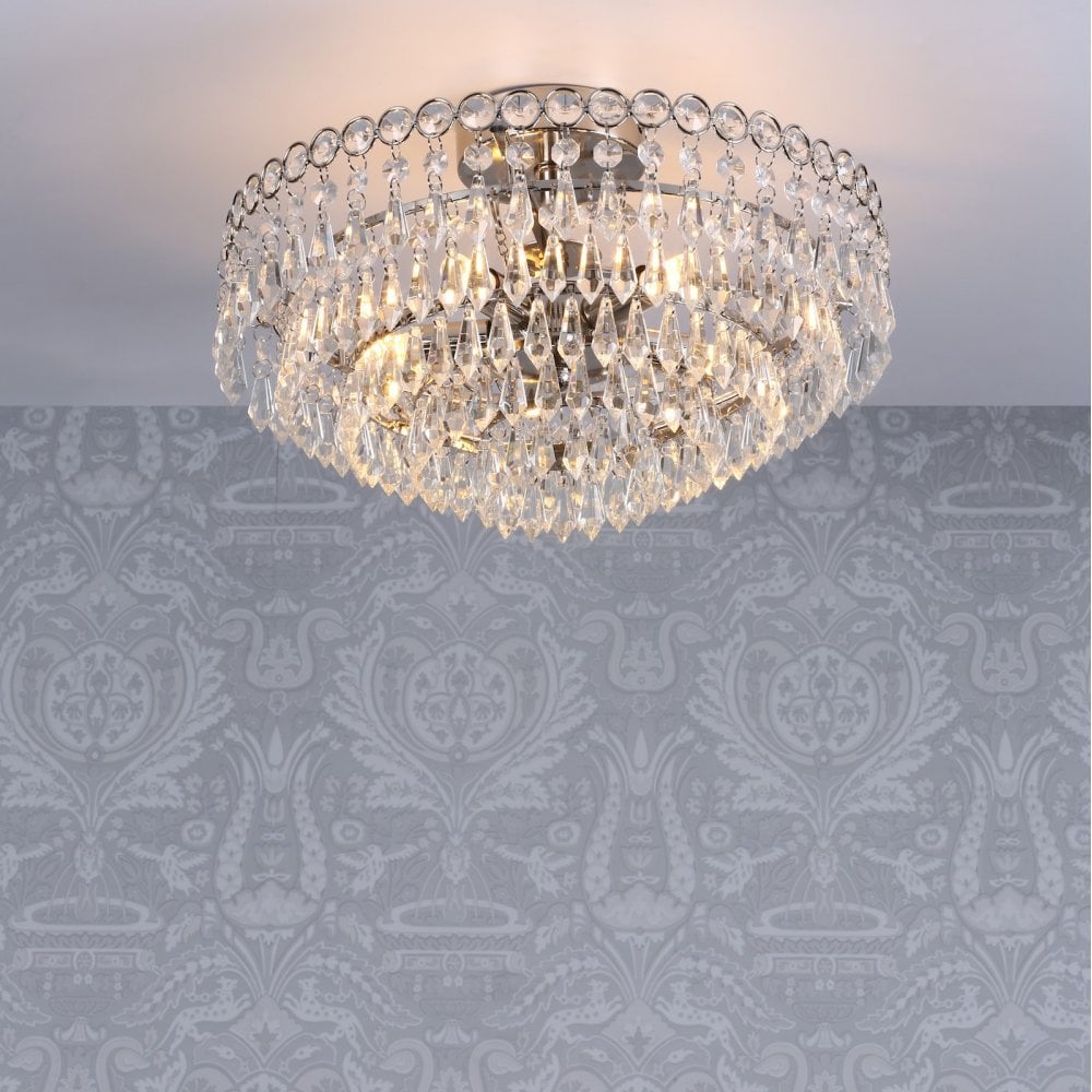 Crystal chandelier on a patterned grey ceiling, viewed from a low angle.