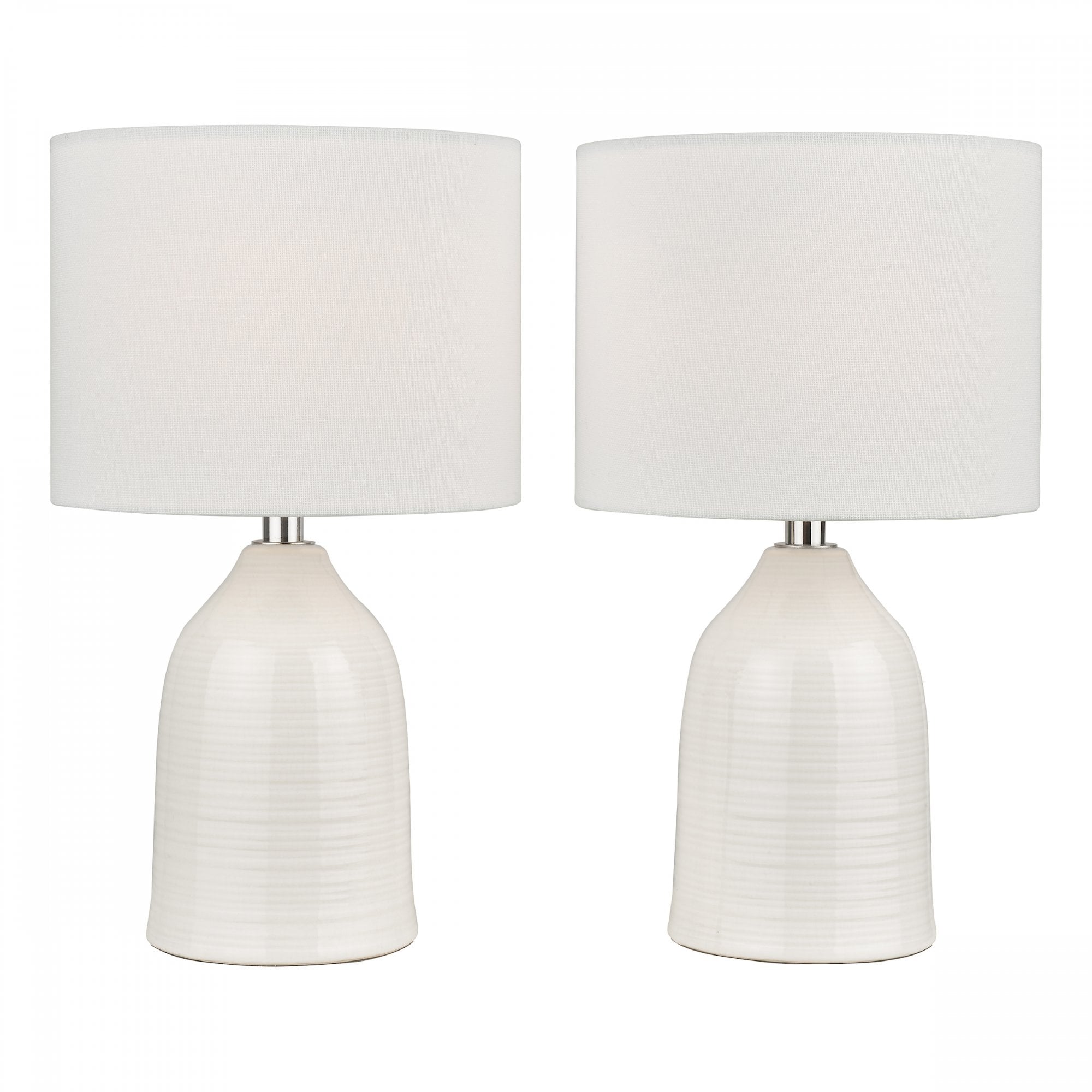 Two white ceramic table lamps with drum shades against a white background.