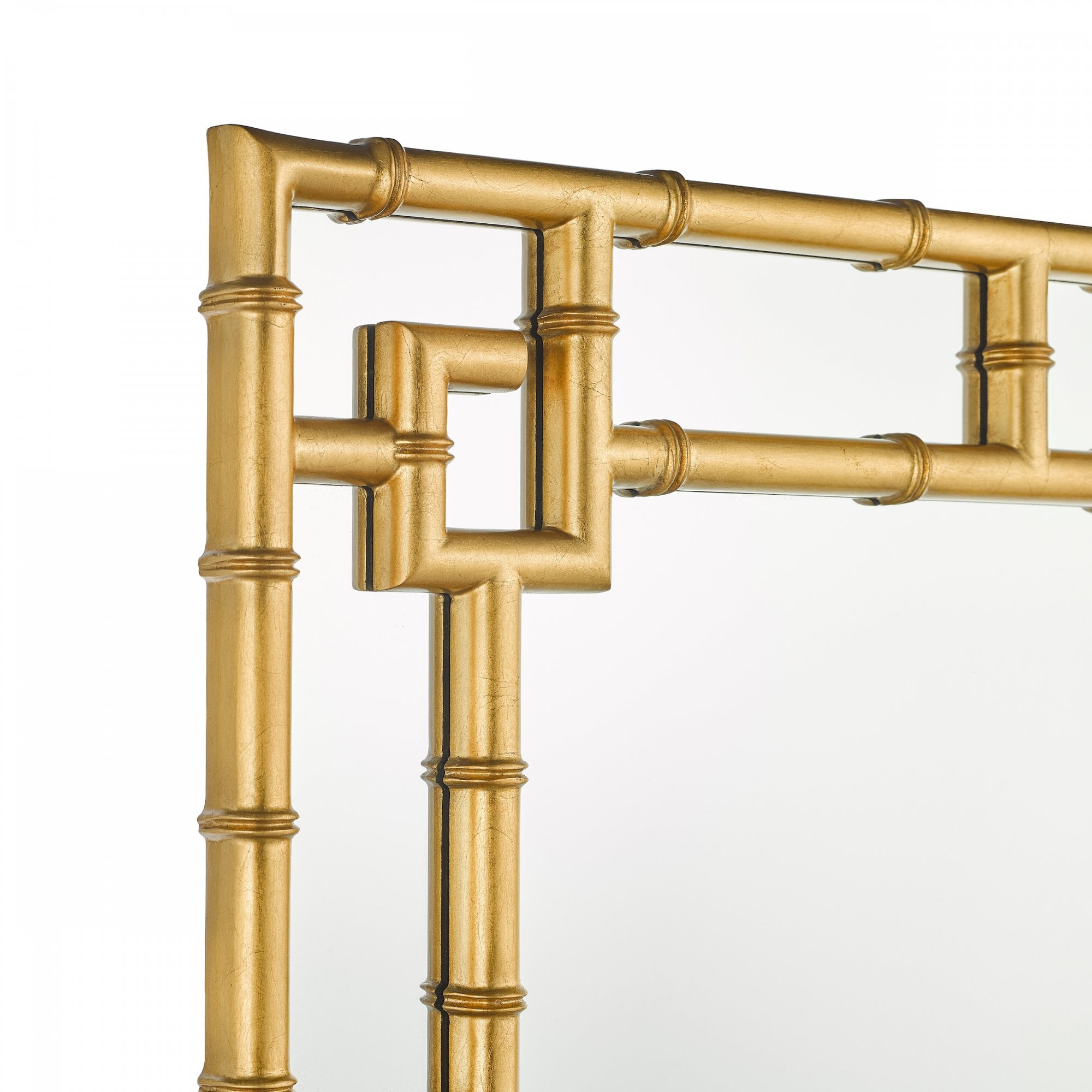Detailed view of the top corner of a gold bamboo framed mirror.