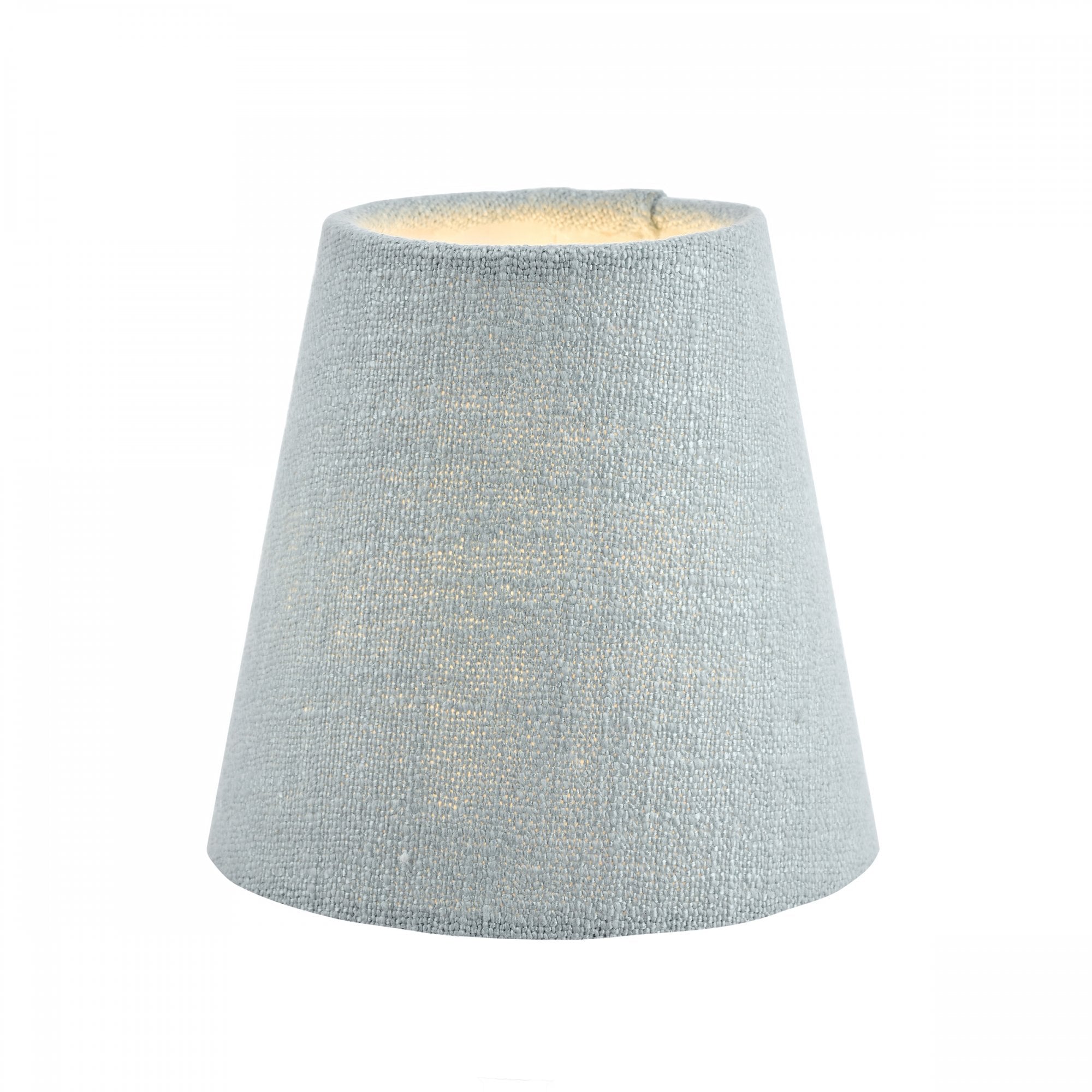 A small light blue fabric lamp shade with a warm glow from within, for ambient lighting.