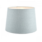 An extra-large light blue fabric lamp shade with a warm glow from within, for ample lighting.