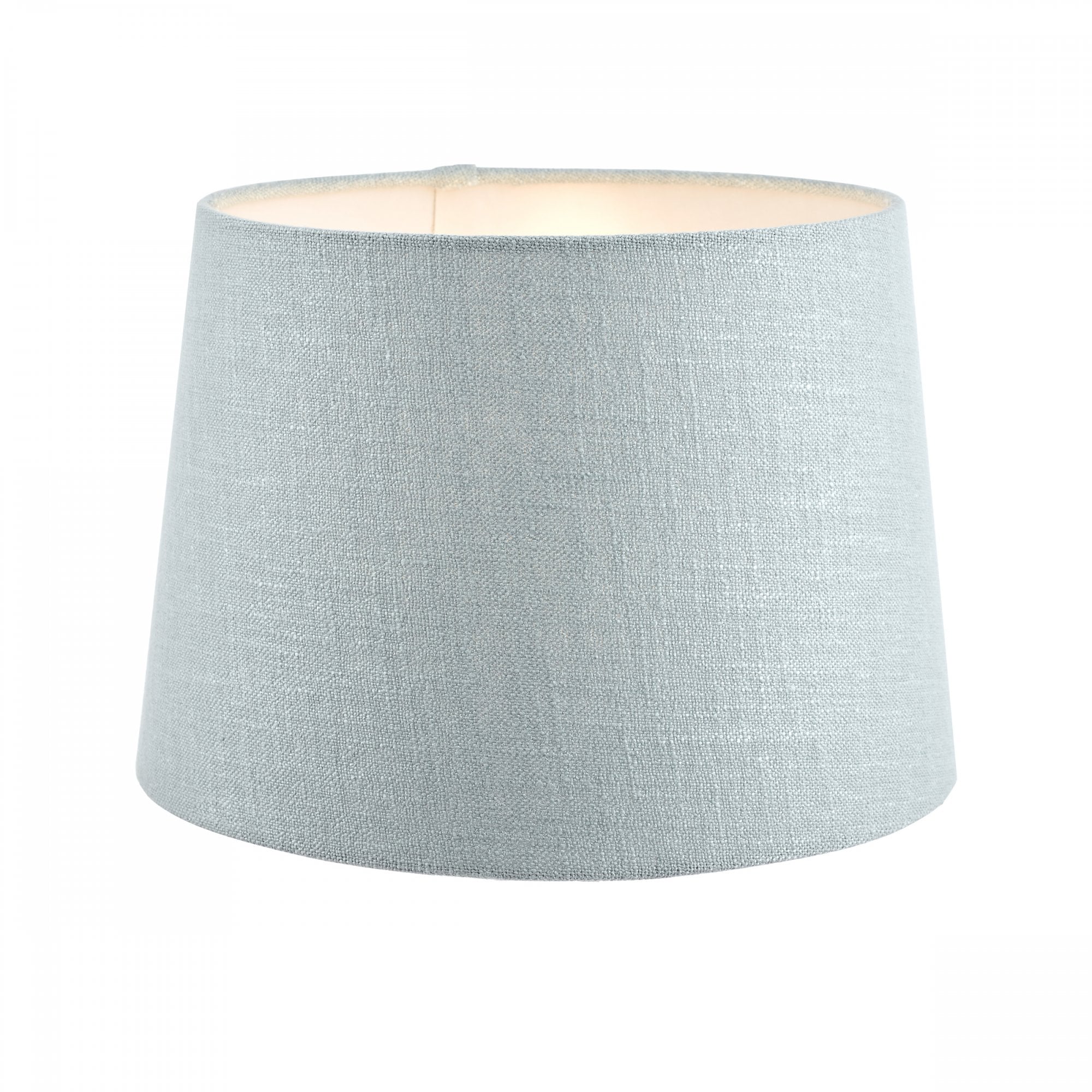 An extra-large light blue fabric lamp shade with a warm glow from within, for ample lighting.
