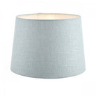 A monumental light blue fabric lamp shade with a gentle inner glow, for significant light spread.