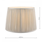 Pleated soft grey lamp shade with light on, showing the internal bulb glow and dimensions.