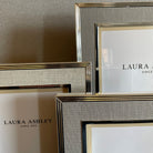A collection of champagne-colored Laura Ashley photo frames in various sizes.