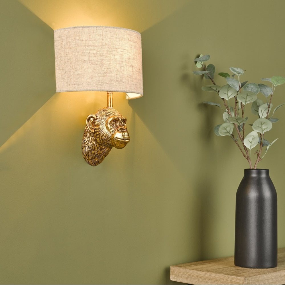 Stylish monkey head wall light casting ambient glow in a corner with a plant.
