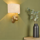 Stylish monkey head wall light casting ambient glow in a corner with a plant.