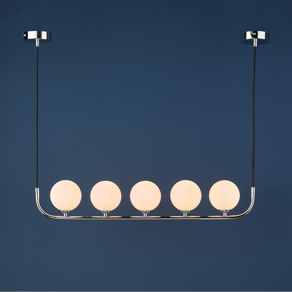 A modern chrome linear pendant light with five white globe shades, against a dark blue background.