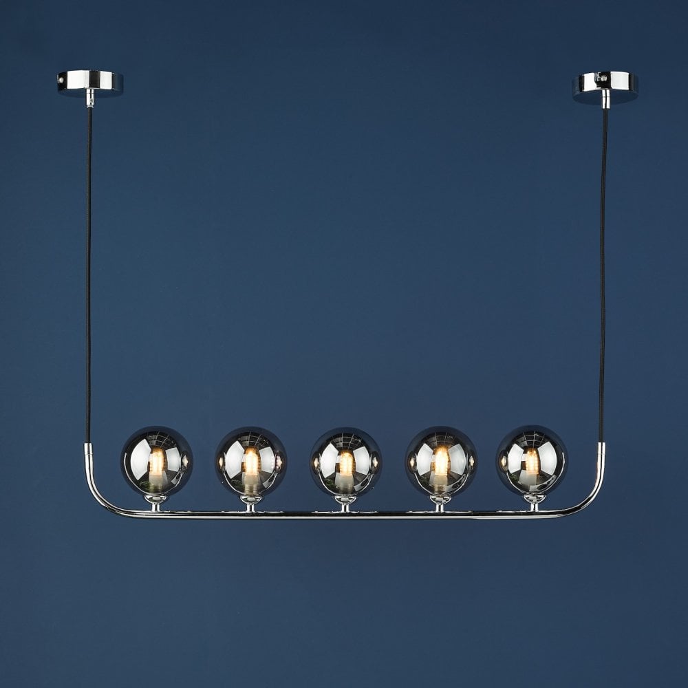 A linear pendant light with five smoky glass globes against a deep blue background.