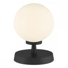 A sleek, modern table lamp featuring a spherical opal glass shade on a black base.