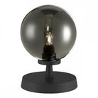 Table lamp with a smoked glass sphere and a visible bulb on a black base.