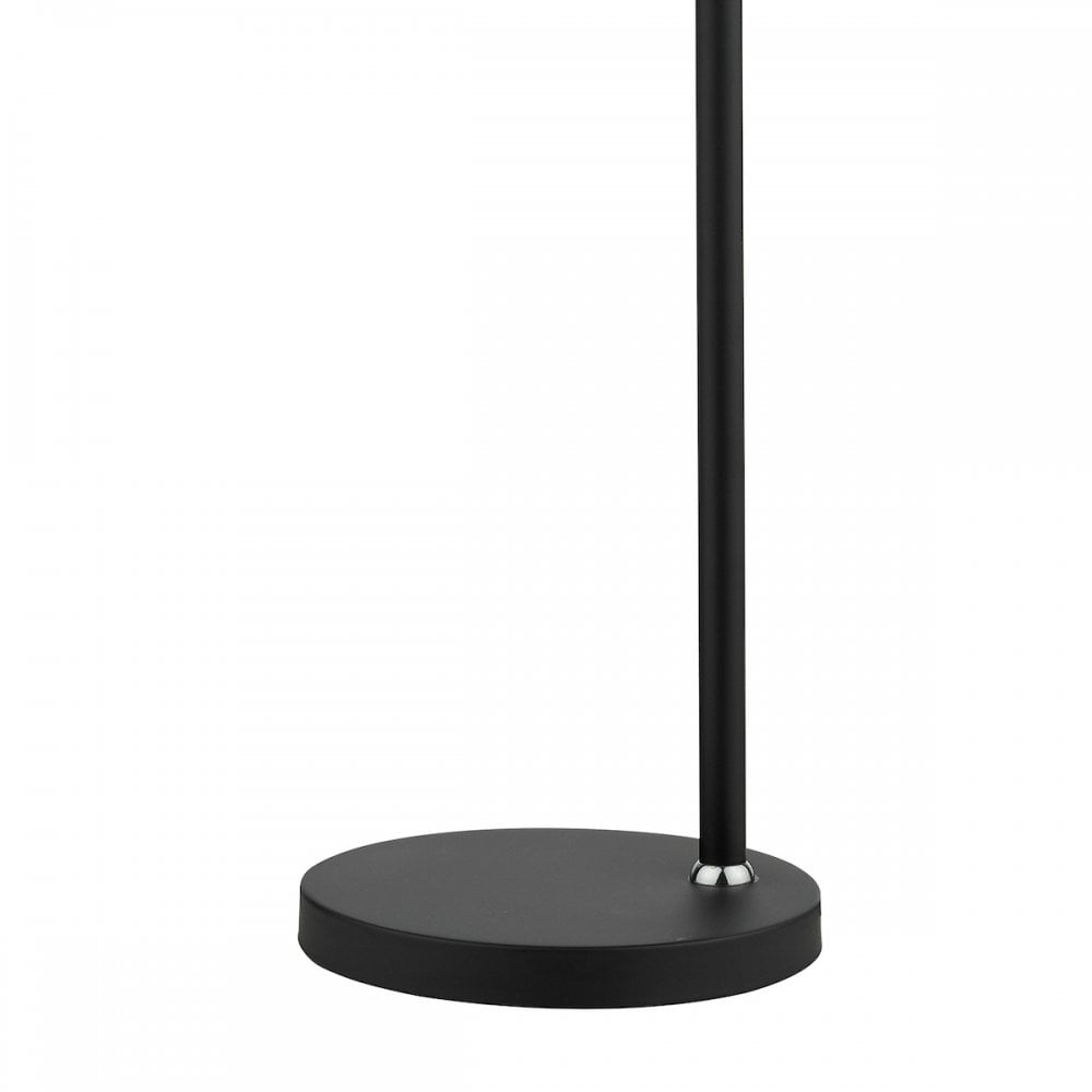 Detail of the round black base and slender pole of a modern table lamp.