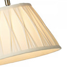 Close-up of the pleated cream fabric shade of the table lamp.