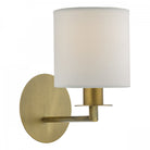 A brass wall light with a white fabric shade, providing a soft glow.