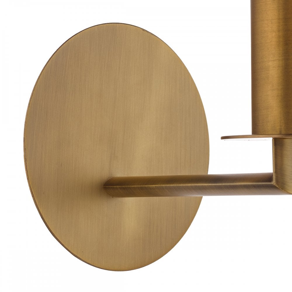 A close-up of the round brass base of a wall light.
