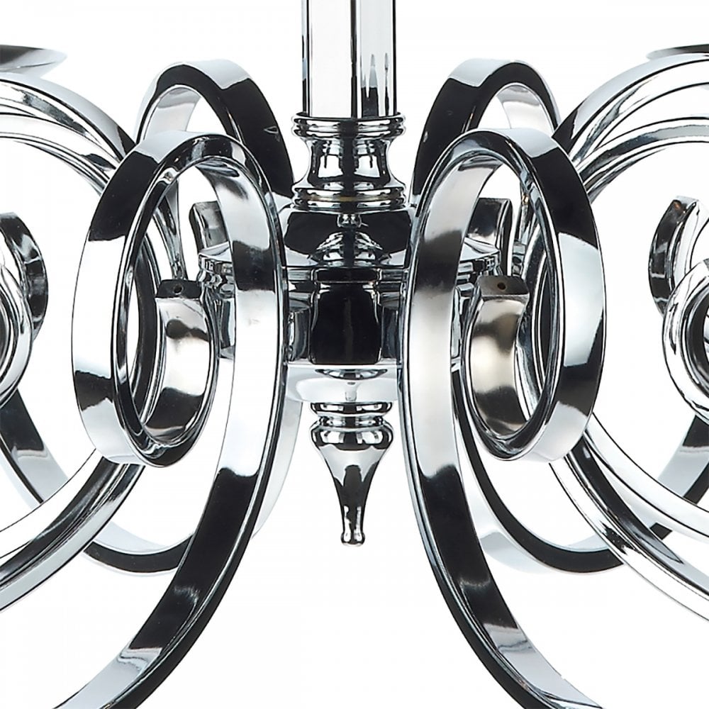 Close-up of the center of a silver chandelier with decorative, swirling arms.