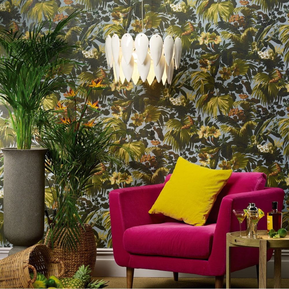 A modern room with a white petal pendant light, a pink armchair, and jungle-themed wallpaper.