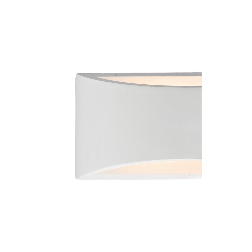 A close-up of a white wall sconce, showing light glowing from its top and bottom edges.