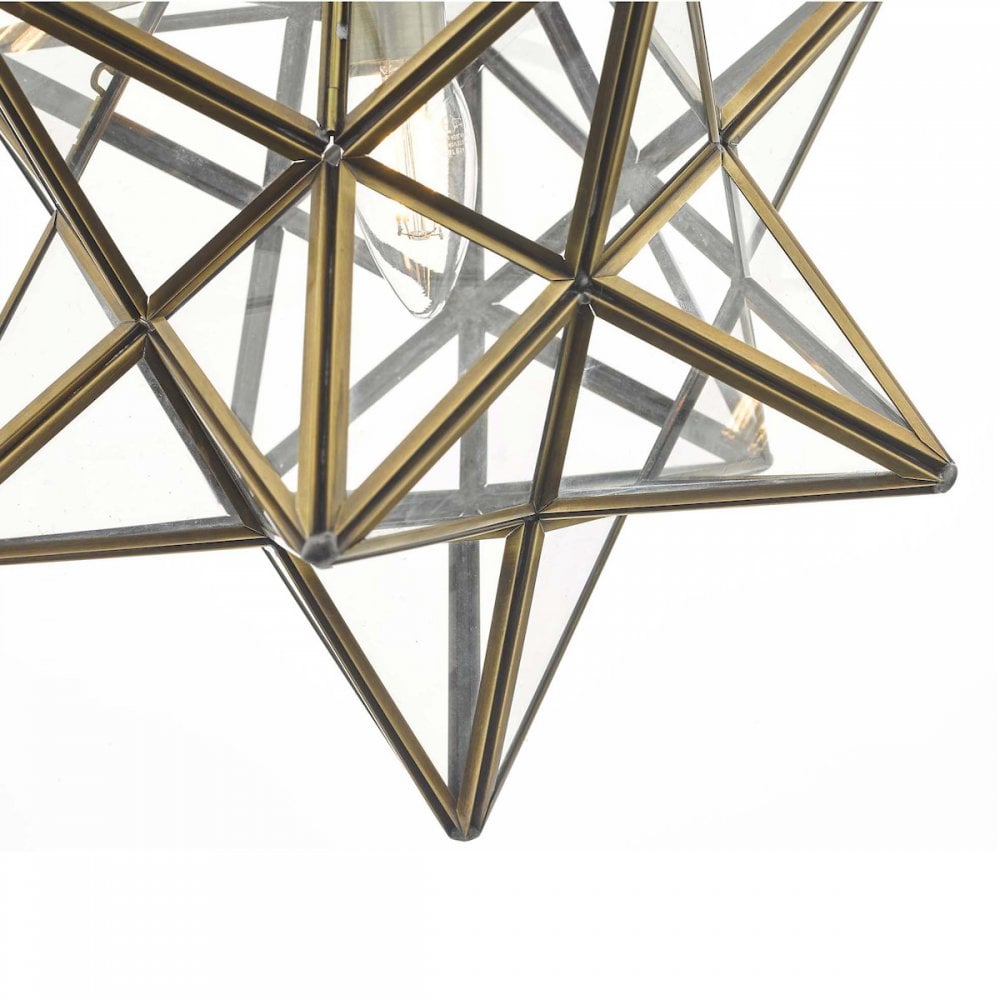 Detailed view of the star-shaped pendant light's geometric glass and brass design.