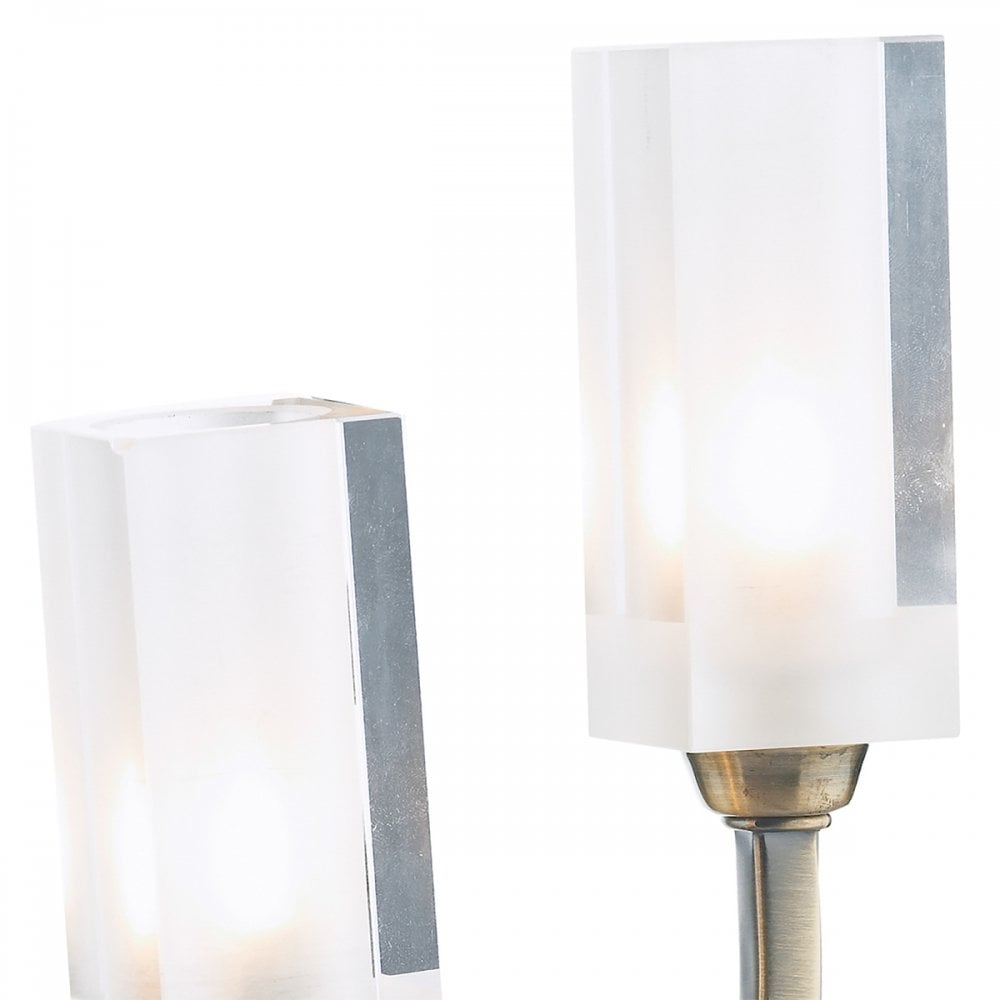 Close up of two clear rectangular shades with bulbs in an antique brass wall light.
