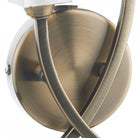 Close up of the antique brass curved base of a wall light.