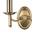 Close-up of the left side of a brass twin wall light fixture.