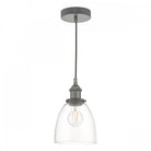 A glass and grey pendant light with a clear bell-shaped shade and an exposed bulb.