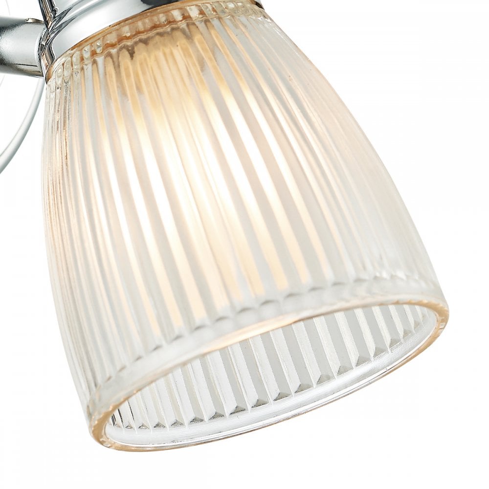 A close up of the clear ribbed glass shade of a lit wall light.