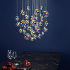 The multi-pendant chandelier illuminating a dining table with pomegranates and wine glasses.