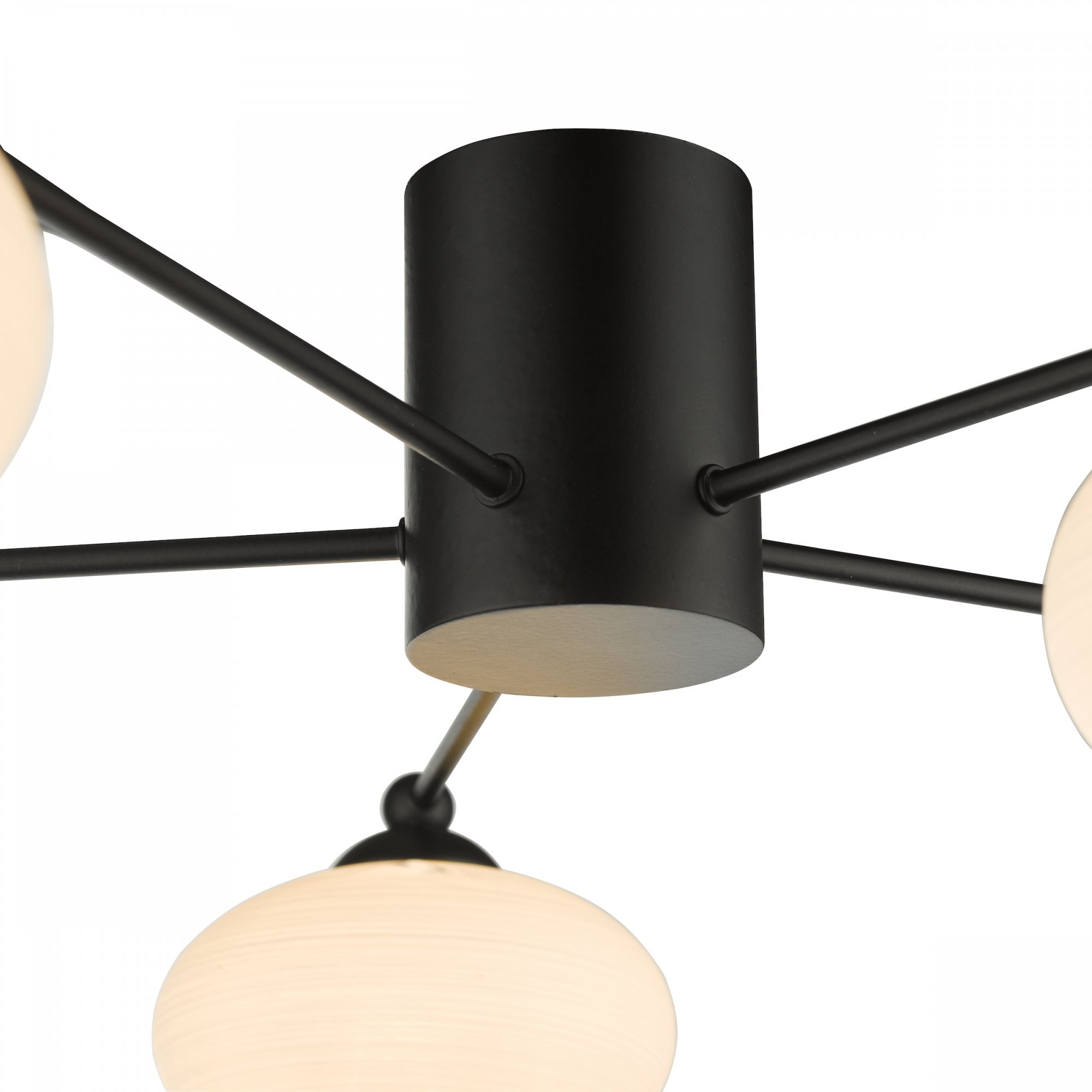 Close-up of the black cylindrical base and arms of a modern ceiling light.